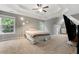 Spacious main bedroom featuring a tray ceiling, carpeted floors, and windows at 2994 Meadow Church Rd, Suwanee, GA 30024