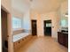 Bathroom boasts a luxurious soaking tub with tile surround and decorative window for natural light at 3784 The Great Dr, Atlanta, GA 30349