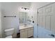 Bright bathroom featuring a single sink vanity and a white paneled door at 3784 The Great Dr, Atlanta, GA 30349