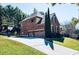 Brick house with a three car garage and basketball hoop, surrounded by lush green trees at 3784 The Great Dr, Atlanta, GA 30349