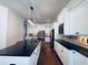 A modern kitchen featuring white cabinets, dark countertops, stainless appliances, and a view of the hardwood floors at 3784 The Great Dr, Atlanta, GA 30349