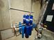 Water filtration system with blue filter canisters, white piping and a concrete wall for context at 3784 The Great Dr, Atlanta, GA 30349