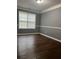 Well-lit room with dark wood floors, large window, and white trim at 3953 Cress Way Run, Decatur, GA 30034