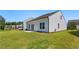 View of backyard features lush green lawn and white siding on home and leads to a small patio with double doors at 803 Levi Farms Ln, Canton, GA 30115