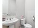 Clean powder room with a pedestal sink, a toilet, and a mirror at 803 Levi Farms Ln, Canton, GA 30115