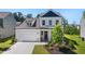 Charming two-story home with white siding, a covered porch and a two-car garage with a well-manicured lawn at 803 Levi Farms Ln, Canton, GA 30115