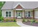 Inviting covered front porch with seating area, beautiful stone accents, and a well-manicured lawn at 10 Berryhill Se Pl, Cartersville, GA 30121
