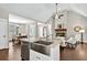 Open kitchen featuring a stainless steel farm sink, granite countertops, and views into the dining and living areas at 10 Berryhill Se Pl, Cartersville, GA 30121