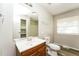 Bright bathroom with a vanity, toilet, and a mirror reflecting the shower at 1034 Sandy Ridge Rd, Mcdonough, GA 30252