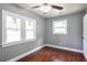 Bedroom features hardwood floors, light grey paint, ceiling fan, and natural light at 10664 Sandpiper Rd, Jonesboro, GA 30238