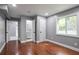 Bedroom features hardwood flooring, neutral paint, and an ensuite bathroom with a window at 10664 Sandpiper Rd, Jonesboro, GA 30238