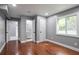 Bedroom featuring hardwood floors, neutral paint, a window, and doors to the bathroom at 10664 Sandpiper Rd, Jonesboro, GA 30238