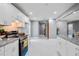 Open kitchen with white cabinets, stainless steel appliances, and marble floors leading to hallway at 10664 Sandpiper Rd, Jonesboro, GA 30238