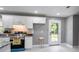 Modern kitchen boasts white cabinets, granite countertops, stainless steel appliances, and a backdoor at 10664 Sandpiper Rd, Jonesboro, GA 30238
