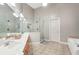 Elegant bathroom with double vanity, glass shower enclosure, soaking tub, and neutral tile at 2297 Herring Woods Way, Grayson, GA 30017
