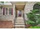 Inviting front entrance featuring brick steps, wrought iron railings, arched window, and a stylish front door at 2297 Herring Woods Way, Grayson, GA 30017