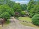 Charming home with a well-manicured lawn and a long driveway surrounded by lush trees at 2297 Herring Woods Way, Grayson, GA 30017