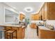 Well-lit kitchen featuring stainless steel appliances, wooden cabinetry, breakfast bar, and open layout design at 2297 Herring Woods Way, Grayson, GA 30017