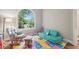 Bright playroom with a large window, rocking chair, and colorful alphabet mat for learning fun at 2297 Herring Woods Way, Grayson, GA 30017