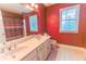 Spacious bathroom featuring a double vanity, large mirror, and decorative wallpaper at 2641 Loch Way, Snellville, GA 30039