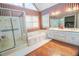 Primary bathroom with jetted tub, walk-in shower, double vanity and wood floors at 2641 Loch Way, Snellville, GA 30039