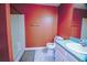 Cozy full bathroom with a shower, toilet, and sink, featuring orange walls and white tile floors at 2641 Loch Way, Snellville, GA 30039