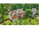 An aerial view of a beautiful brick home featuring a manicured lawn, mature trees, and an attached garage at 2641 Loch Way, Snellville, GA 30039