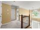 Hallway featuring a staircase with wooden banister and ample natural light from a window at 2641 Loch Way, Snellville, GA 30039