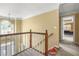 Upstairs hallway with wooden banister and view into the bedroom at 2641 Loch Way, Snellville, GA 30039