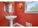 Bright half bathroom featuring a pedestal sink and unique wall decor at 2641 Loch Way, Snellville, GA 30039
