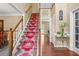 Inviting foyer with a grand staircase featuring a vibrant runner and hardwood floors at 2641 Loch Way, Snellville, GA 30039