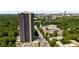 Beautiful exterior shot of a luxurious condominium with a tree canopy with a city skyline at 2660 Peachtree Nw Rd # 13H, Atlanta, GA 30305