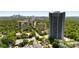 High-rise condominium building showcases a lush tree canopy with a downtown skyline in the background at 2660 Peachtree Nw Rd # 13H, Atlanta, GA 30305