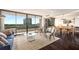 Bright living room with hardwood floors, floor to ceiling windows, and adjoined dining area at 2660 Peachtree Nw Rd # 13H, Atlanta, GA 30305
