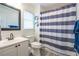 This bathroom features a blue-and-white striped shower curtain and a vanity with a white countertop at 5589 Forkwood Nw Dr, Acworth, GA 30101