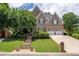 Charming two-story brick home featuring a well-manicured lawn, mature trees, and a two-car garage at 5589 Forkwood Nw Dr, Acworth, GA 30101