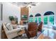 Open living room boasts a stone fireplace, soaring ceilings, large arched windows, and hardwood flooring at 5589 Forkwood Nw Dr, Acworth, GA 30101