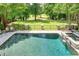 Inviting pool area with stone patio, spa, and distant golf course views surrounded by lush greenery at 5589 Forkwood Nw Dr, Acworth, GA 30101