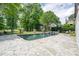 Tranquil backyard with a large pool, stone patio, and lush greenery creating a peaceful retreat at 5589 Forkwood Nw Dr, Acworth, GA 30101