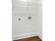 Laundry room with white walls, wood floors, wire rack shelf, and plumbing access at 380 Atwood Nw Dr, Marietta, GA 30064