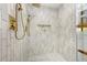 Close up of shower with gold hardware, sleek vertical tile, shower niche, and marble hexagon floor at 380 Atwood Nw Dr, Marietta, GA 30064