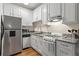 Efficient kitchen features white cabinets, granite countertops, and stainless steel appliances at 242 12Th Ne St # 14, Atlanta, GA 30309