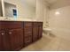 Bathroom with tiled floors, dark wood cabinets, and white porcelain toilet and bathtub at 8265 Village Pl, Suwanee, GA 30024