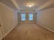 Spacious bedroom featuring tray ceilings and carpeted floors at 8265 Village Pl, Suwanee, GA 30024