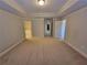 Large bedroom with tray ceilings, carpet floors, and multiple doorways at 8265 Village Pl, Suwanee, GA 30024