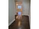 Hallway leading to living spaces with gleaming hardwood floors and neutral paint at 8265 Village Pl, Suwanee, GA 30024