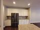 Bright kitchen featuring stainless steel refrigerator, granite countertops, and white cabinets at 8265 Village Pl, Suwanee, GA 30024