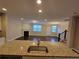 Modern kitchen with granite counters, stainless steel sink, and view of the living room at 8265 Village Pl, Suwanee, GA 30024