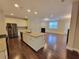 Open concept kitchen with stainless steel appliances, granite countertops, and hardwood floors at 8265 Village Pl, Suwanee, GA 30024