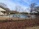 Community pool surrounded by mature trees, lounge chairs and a black aluminum fence at 8265 Village Pl, Suwanee, GA 30024